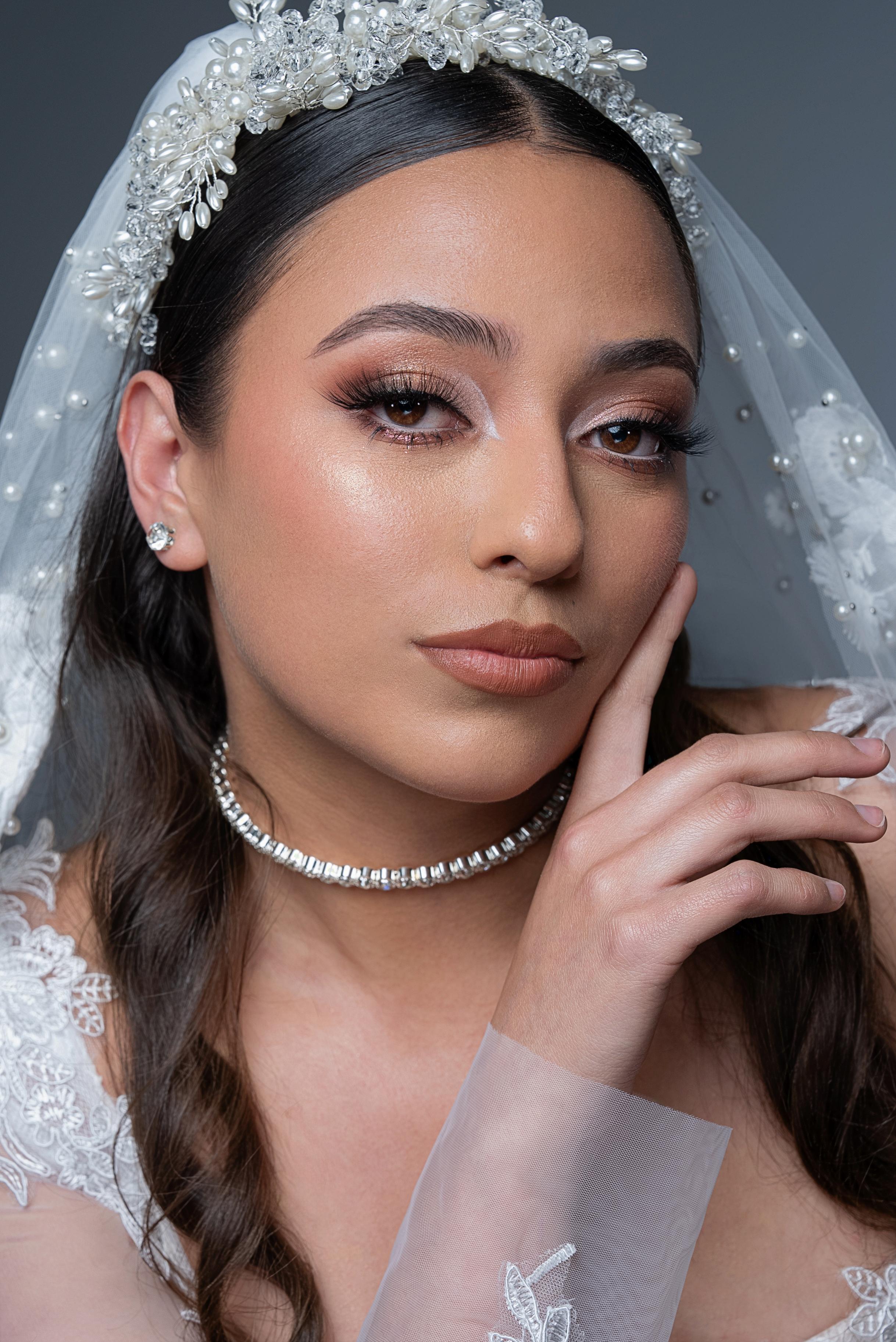 Retrato de novia con corona de perlas, velo y maquillaje luminoso