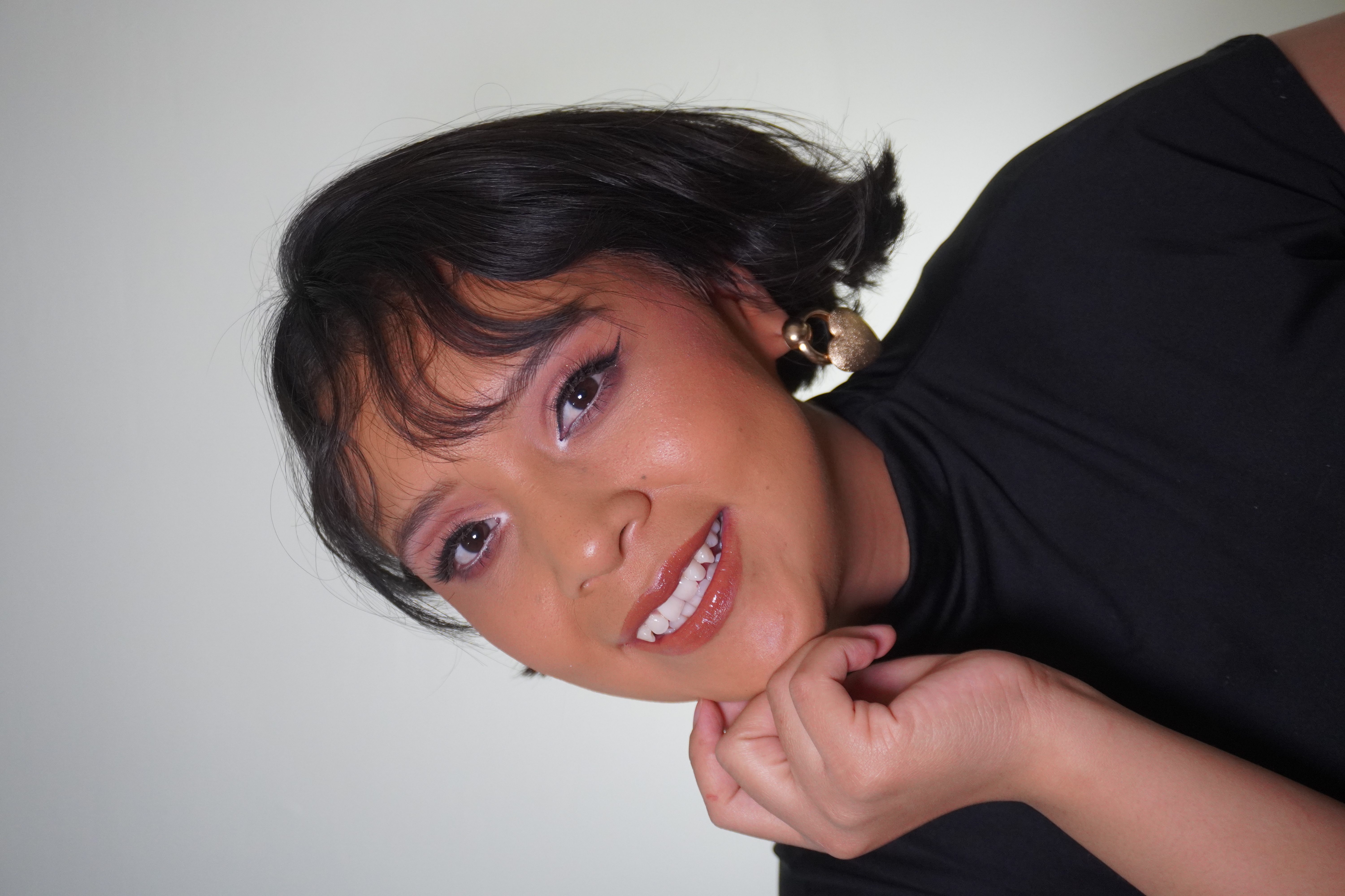 Retrato sonriendo con maquillaje suave y aretes dorados