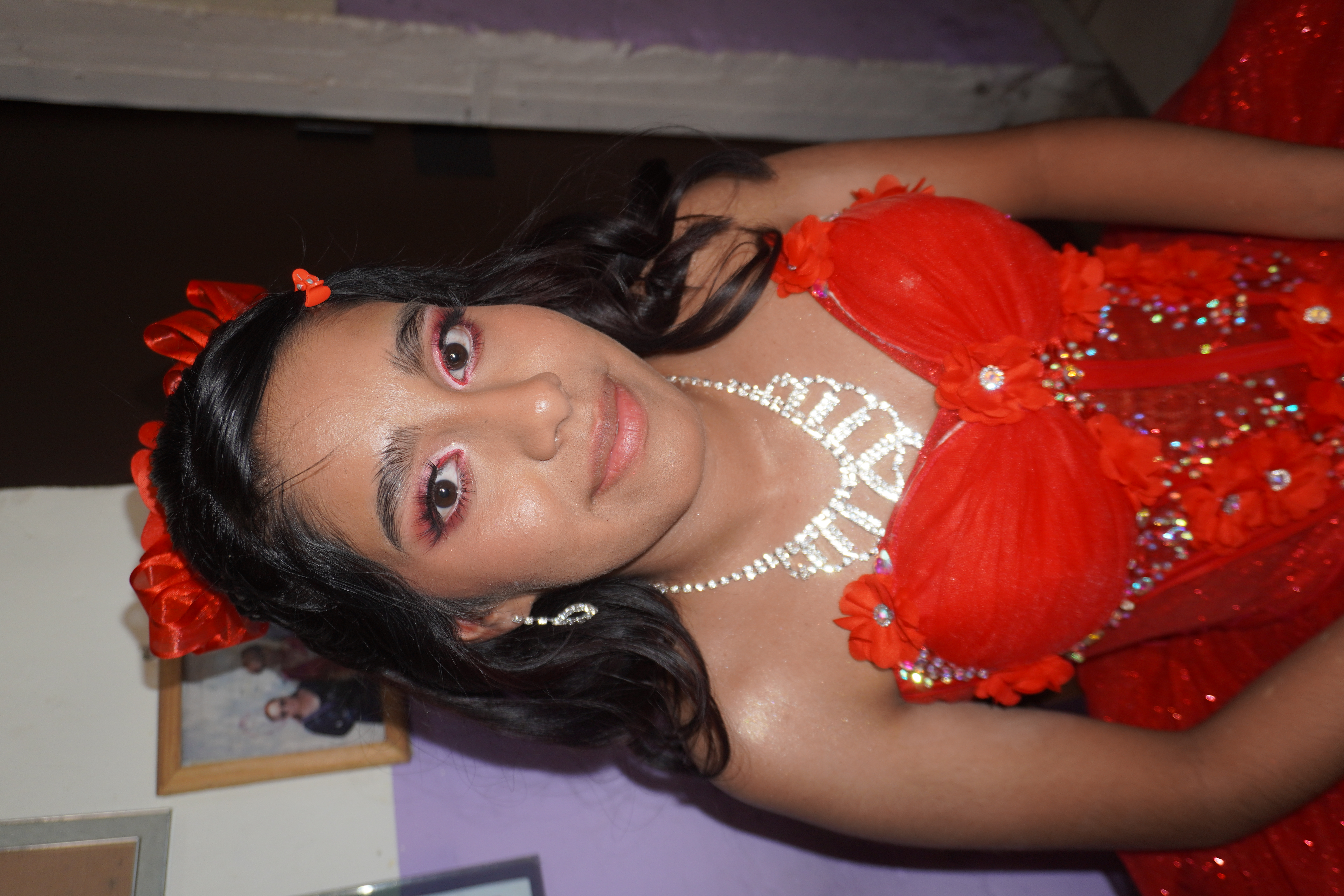 Retrato de evento con vestido rojo y maquillaje en tonos calidos